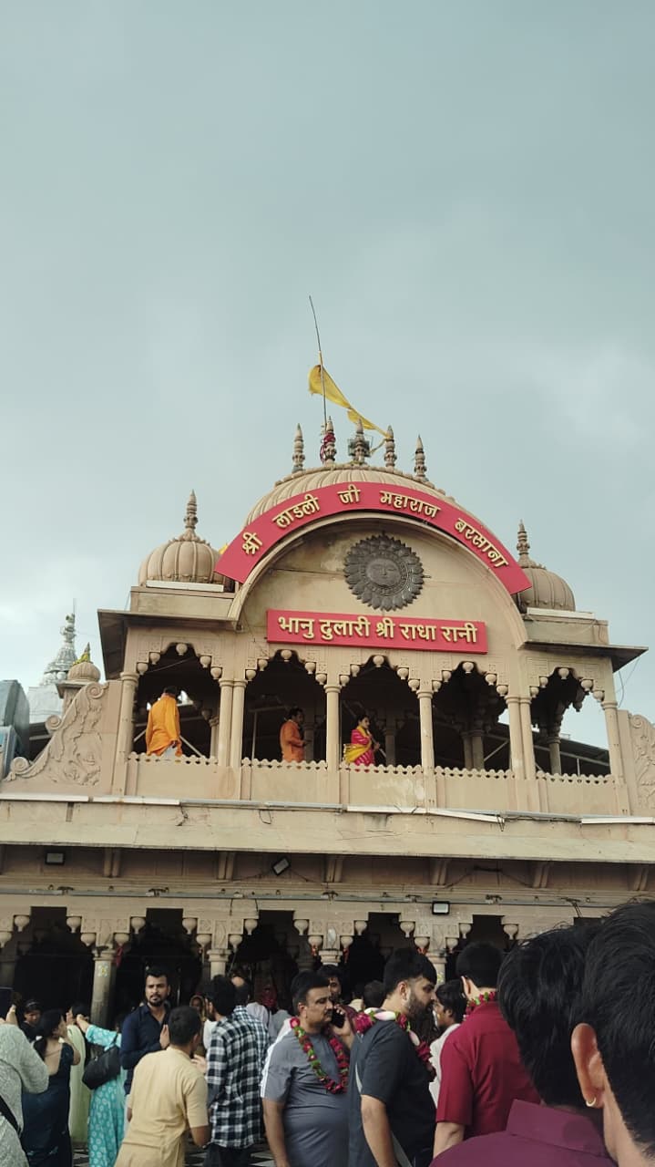 The facade of Radha Rani Mandir in Barsana, with devotees below