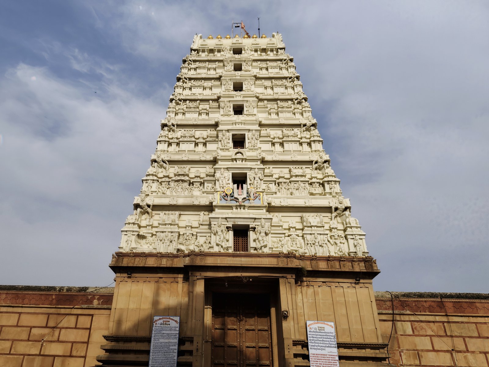 The tall carved gopuram tower of Rangji Mandir rising against the sky above its entrance gate